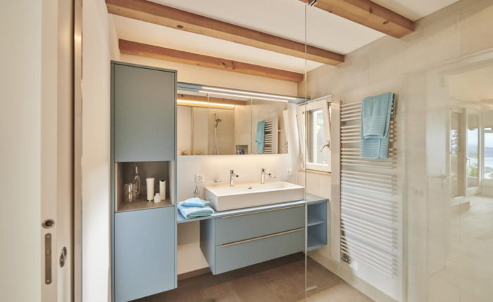 Renoviertes Badezimmer mit Dusche und blauen Badezimmermöbel