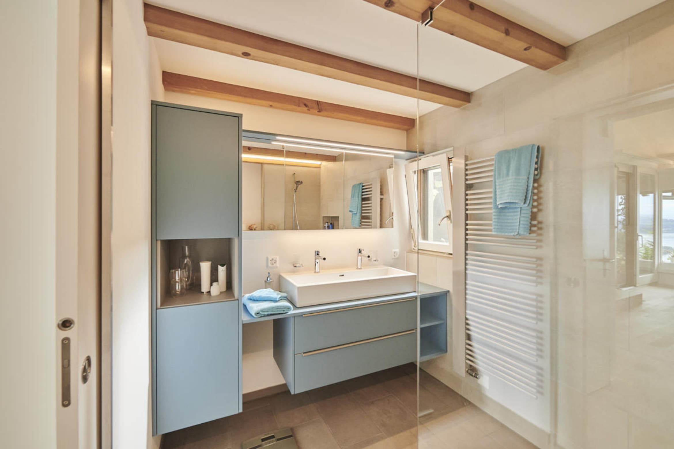 Renoviertes Badezimmer mit Dusche und blauen Badezimmermöbel